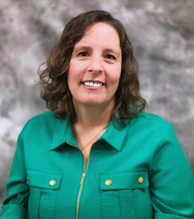 Woman with short brown hair wearing a zipper up shirt