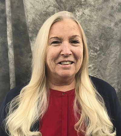 Woman with long blonde hair wearing a blouse and suit jacket