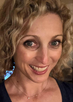 Woman with short, curly blondw hair wearing a black shirt