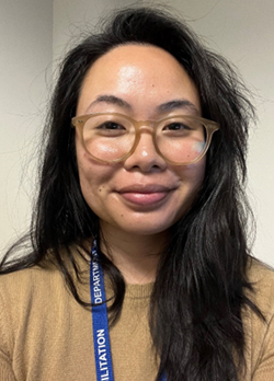 woman with black hair wearing a light brown shirt